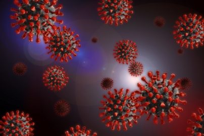 3D illustration of coronavirus particles showing red spike proteins on a dark background.